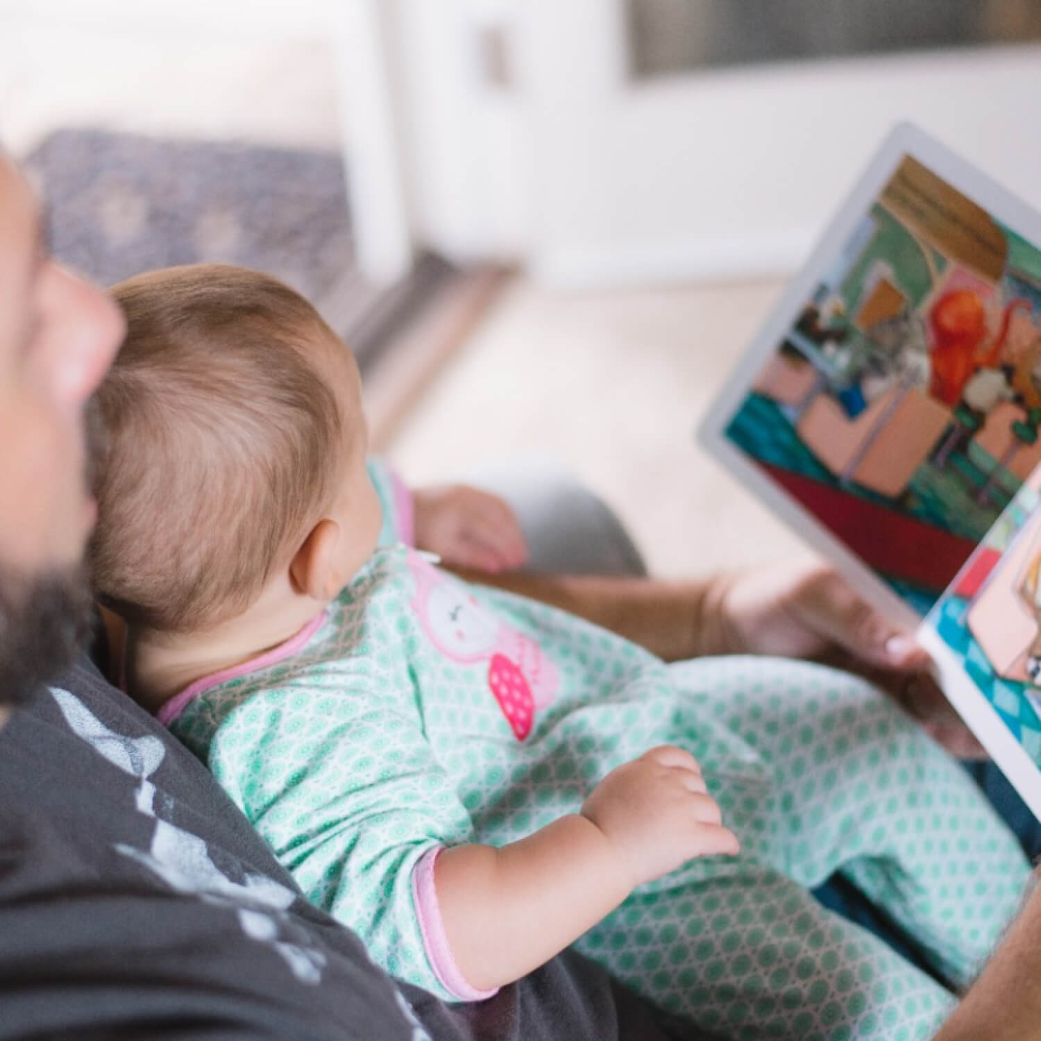 Bébé sur genoux d'homme avec livre